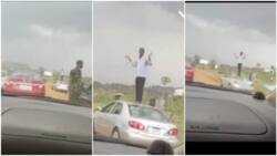 Man drives against traffic in Abuja, soldier catches him, orders him to stand on his car and wave to people