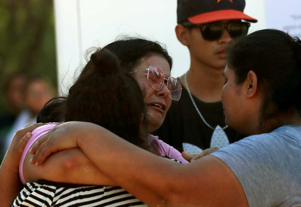 Relatives comfort each other after 10 miners were trapped in a cave-in in northern Mexico