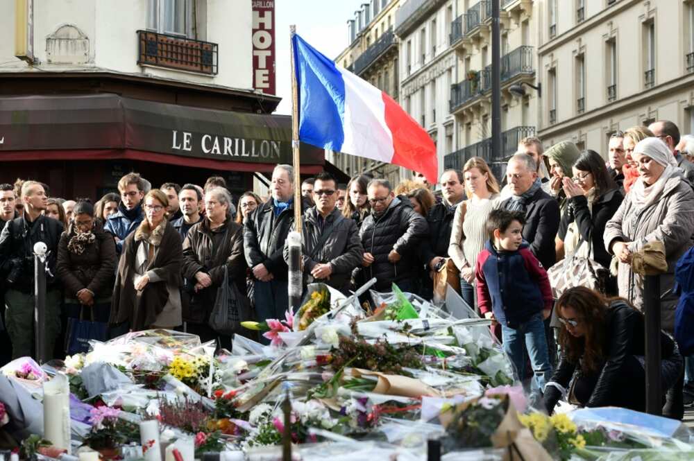 People pay tribute to the victims of the terror attacks as they gather at a makeshift memorial outside Le Carillon cafe in Paris, on November 16, 2015