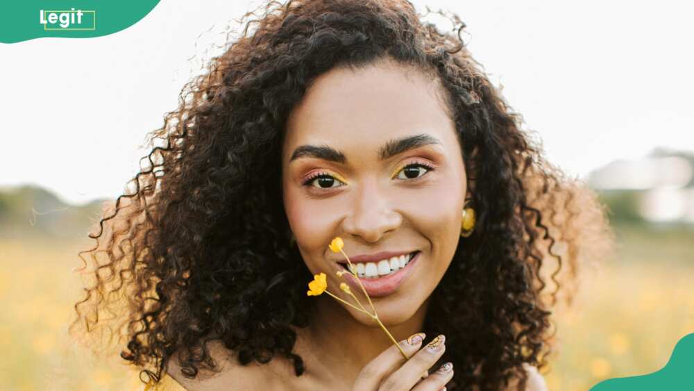 A woman smelling a yellow flower