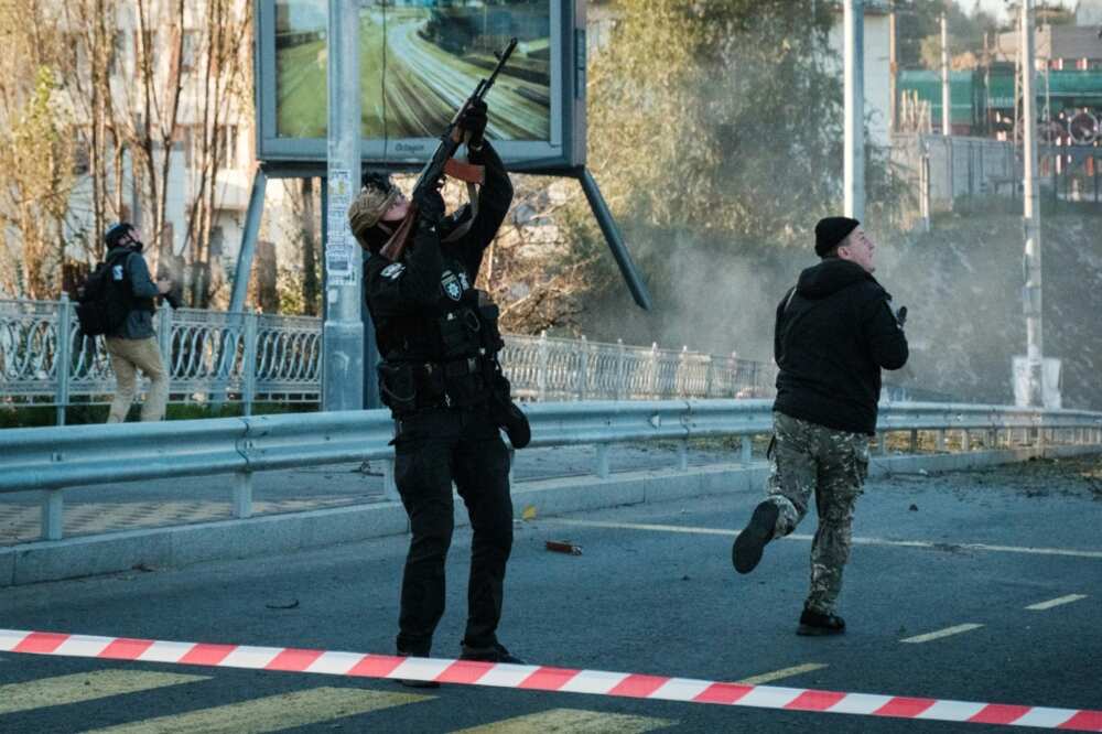 A police officer fires at a flying drone following attacks in Kyiv on October 17, 2022, amid the Russian invasion