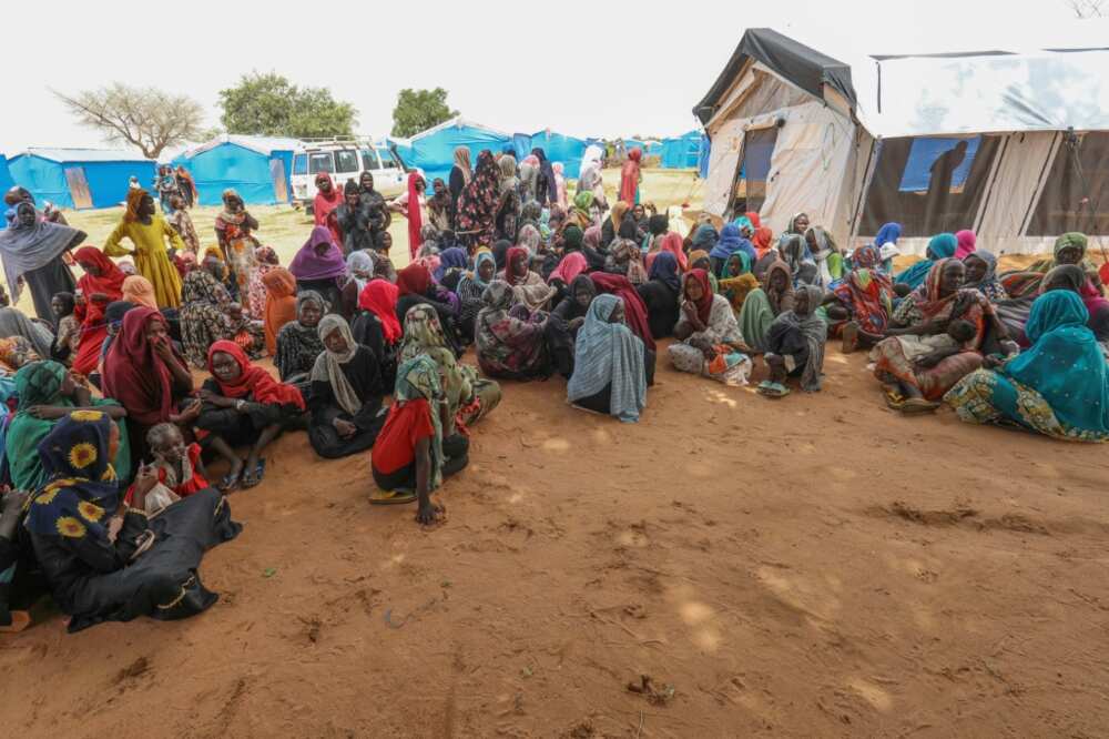 Women who fled the war in Sudan await the distribution of international aid rations at the Ourang refugee camp, near Adre town in eastern Chad on August 15, 2023