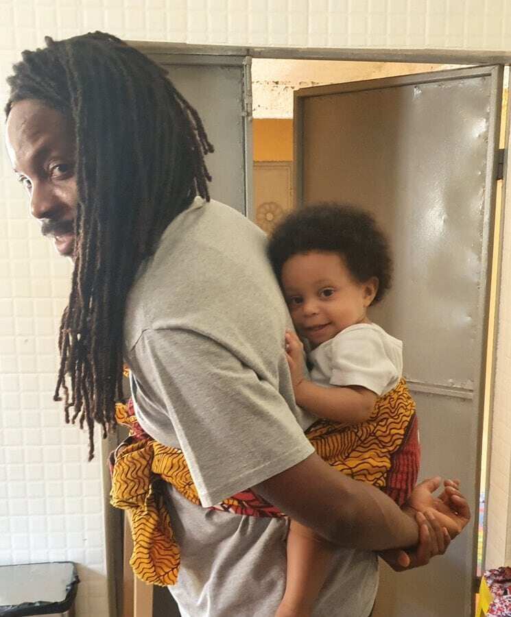 Working from home: Sierra Leone Minister feeds, carries 10-month-old daughter on his back during Zoom meeting