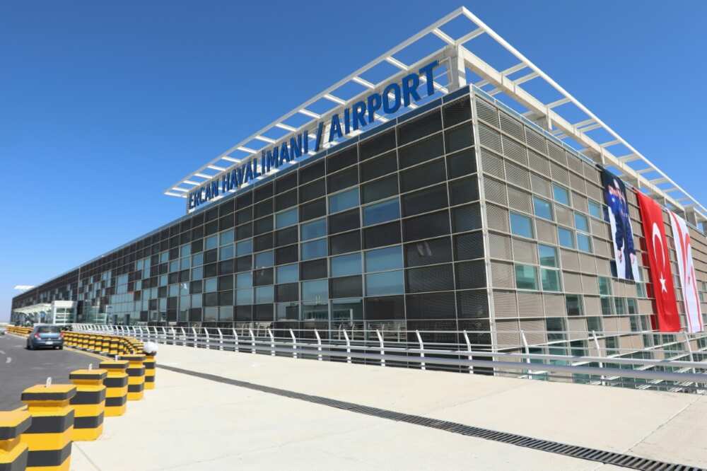 Flags of Turkey and breakaway North Cyprus hang on the facade of the new terminal for its inauguration