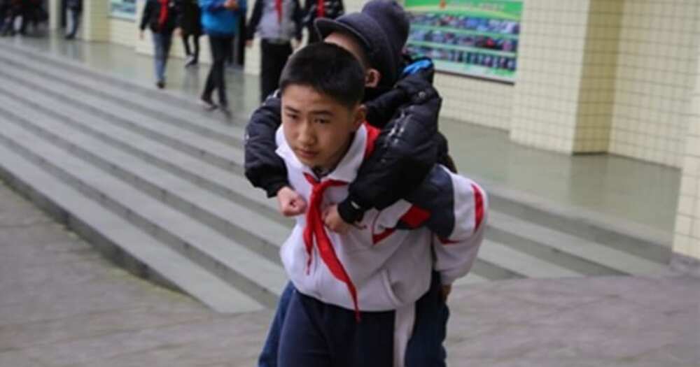 12-year-old schoolboy carries disabled friend to class daily for 6 years (photos)