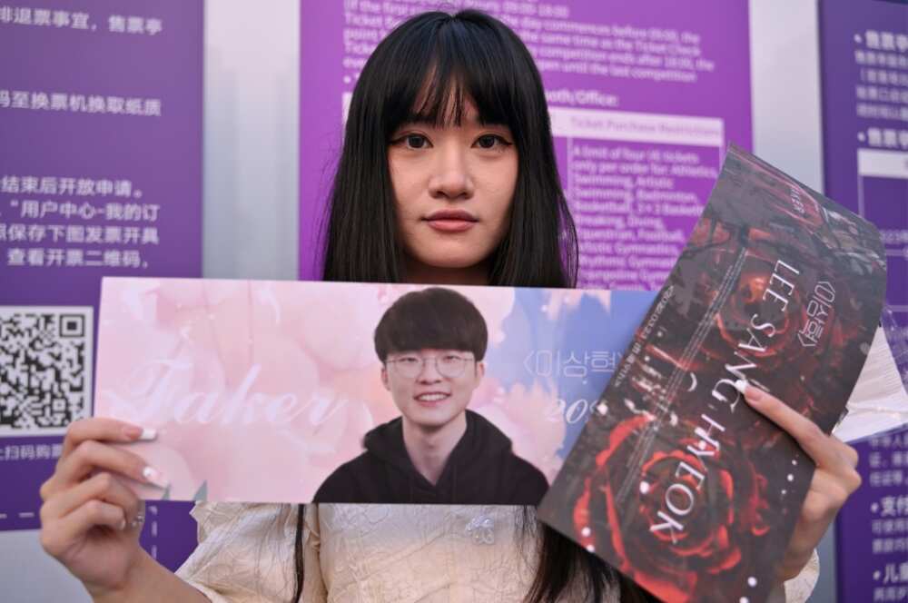A fan of Lee "Faker" Sang-hyeok shows off her sign
