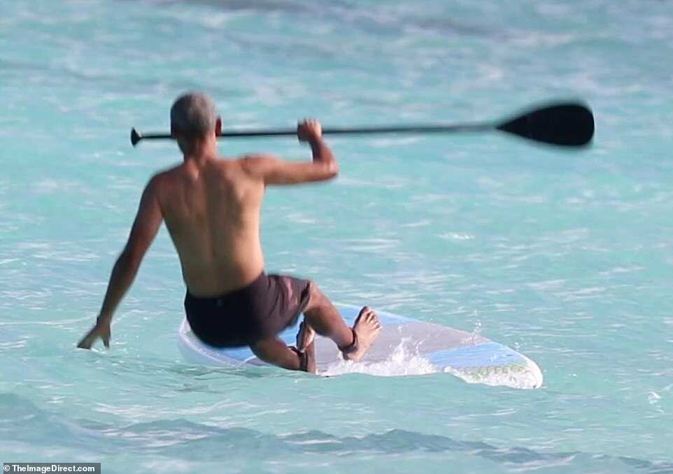 Barack Obama goes paddleboarding shirtless in Hawaii in $84 shark deterrent ankle band Barack Obama goes paddleboarding shirtless in Hawaii in $84 shark deterrent ankle band