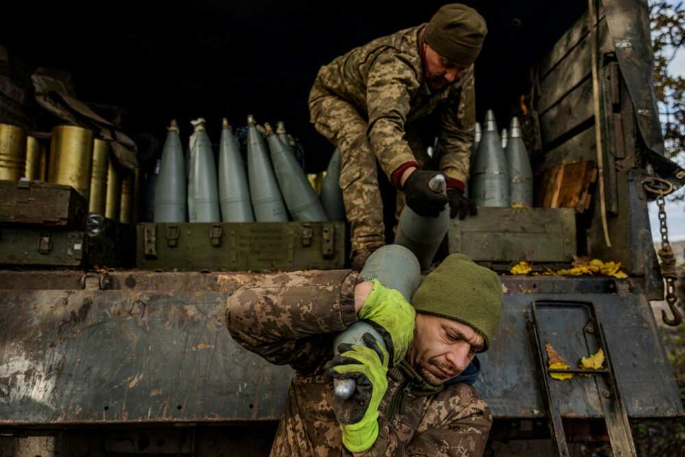 Ukrainian artillerymen unload shells from a military truck on the front line near Bakhmut