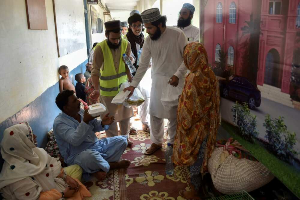 Volunteers from the local chapter of a political party distribute food to displaced people camped in the corridors of a technical college