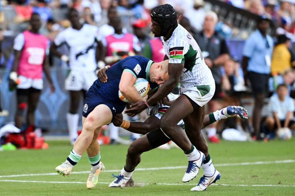 Kenya's Willy Ambaka (C) and Vincent Onyala (R) tackle Scotland's Reiss Cullen in the World Rugby Sevens Series event in Carson, California on August 27, 2022.