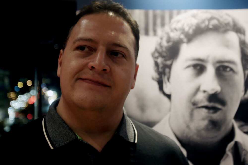 Juan Pablo Escobar en photo avec un portrait de Pablo Escobar