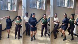 Teacher dances with her students in school corridor, they show cool waist moves in video