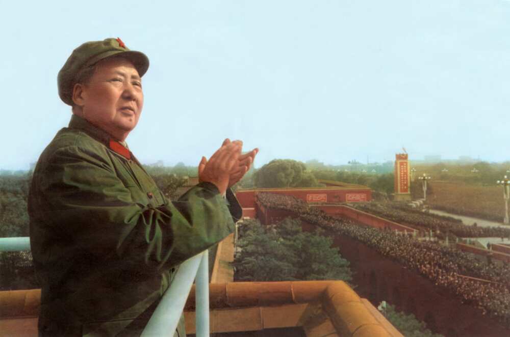Mao Tse Toung clapping his hands in a jungle green outfit