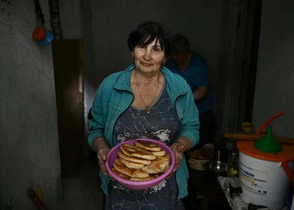 Without power for months, the neighbours cook potato pancakes over a fire Without power for months, the neighbours cook potato pancakes over a fire