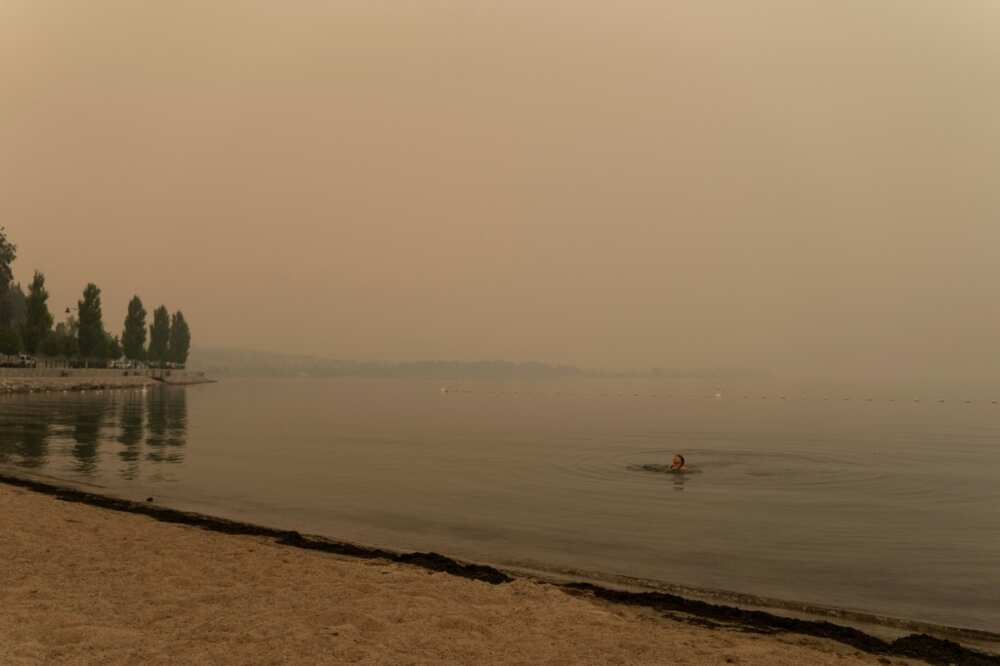 A woman swims in Lake Okanagan covered in wildfires smoke in West Kelowna