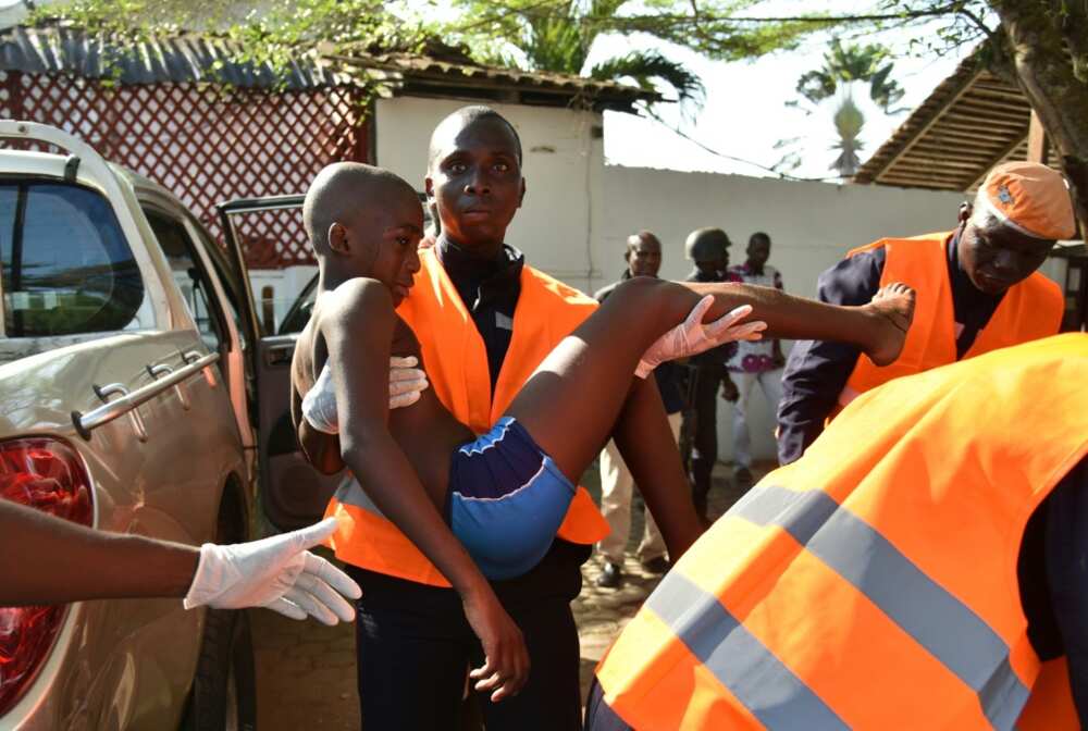 A rescue worker carries a young boy who was wounded in the attack