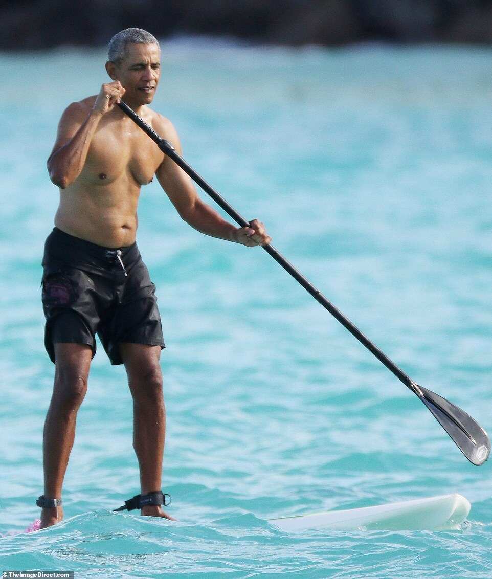 Barack Obama goes paddleboarding shirtless in Hawaii in $84 shark deterrent ankle band Barack Obama goes paddleboarding shirtless in Hawaii in $84 shark deterrent ankle band