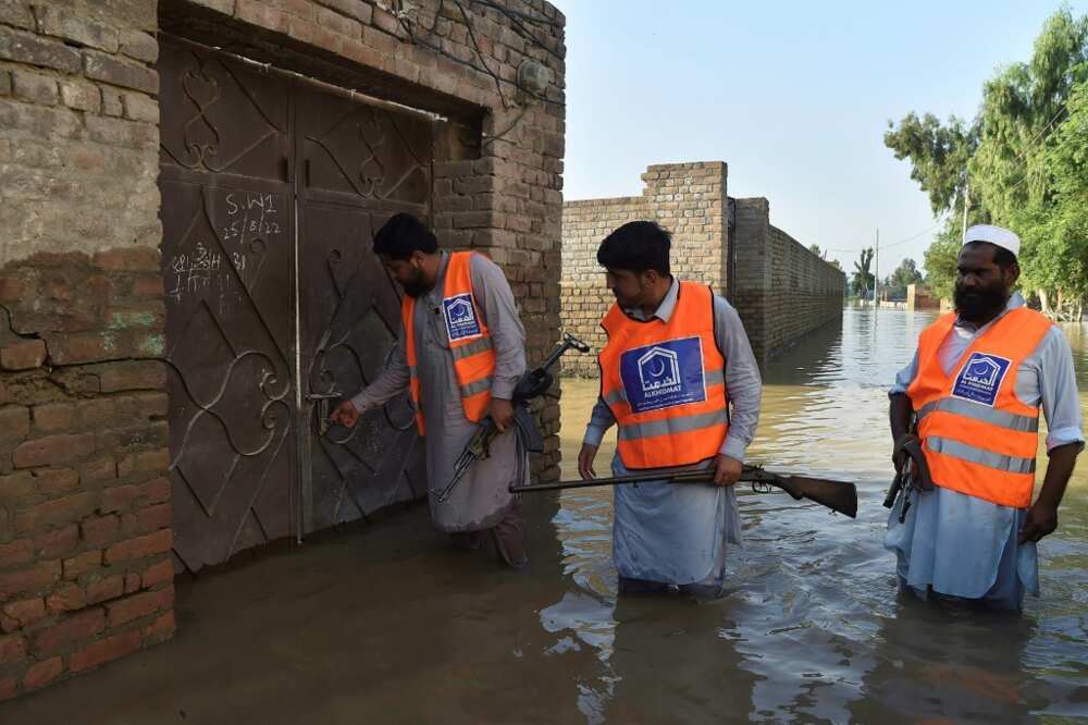 Armed members of a local Muslim charity patrol flooded streets to check abandoned houses for looting in Nowshera, in Pakistan's north