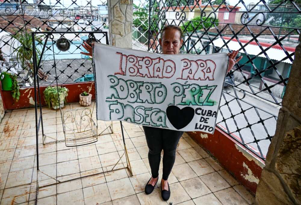 Liset Fonseca, mother of Roberto Perez Fonseca, also detained in the 2021 protests, shows a poster demanding the release of her son