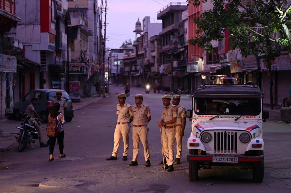 Police stand guard along a deserted street in Udaipur during a curfew imposed by authorities following the killing of Hindu tailor Kanhaiya Lal, allegedly by two Muslim men Police stand guard along a deserted street in Udaipur during a curfew imposed by authorities following the killing of Hindu tailor Kanhaiya Lal, allegedly by two Muslim men