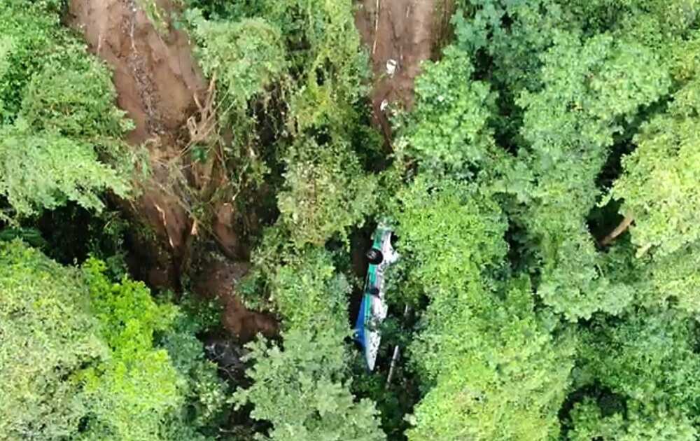 A bus that was pushed off a cliff by a landslide is seen in an image made available by Costa Rica's Fire Department