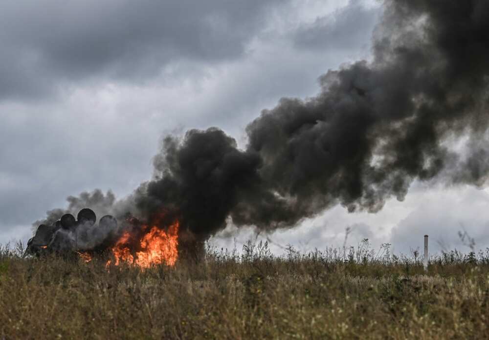A destroyed Russian armoured personnel carrier burns on the outskirts of Izyum
