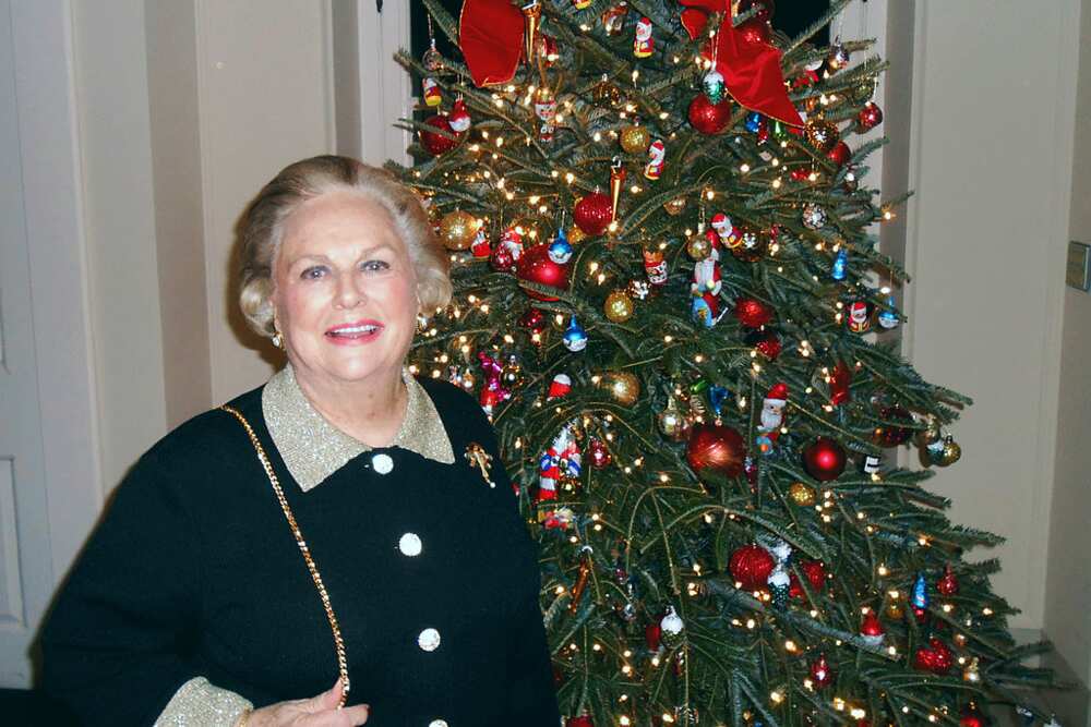 Jacqueline Badger Mars stands next to a decorated Christmas tree