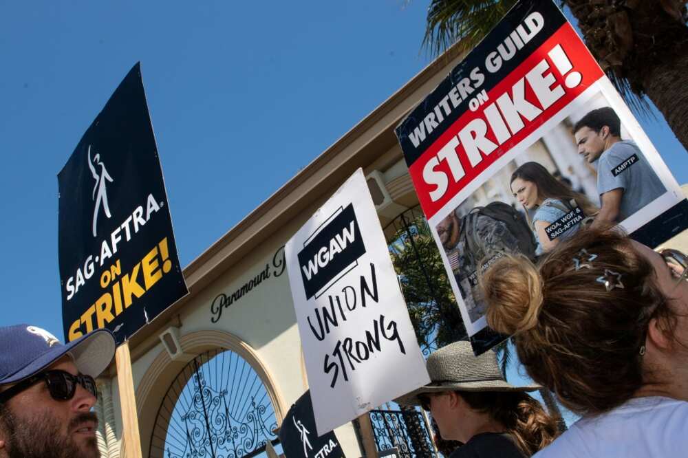 Members of the Writers Guild of America and the Screen Actors Guild walk a picket line outside of Paramount Pictures