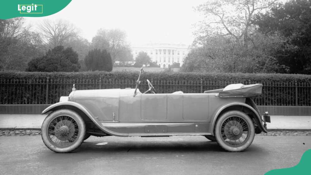 View of a Duesenberg automobile parked on the street outside the White House