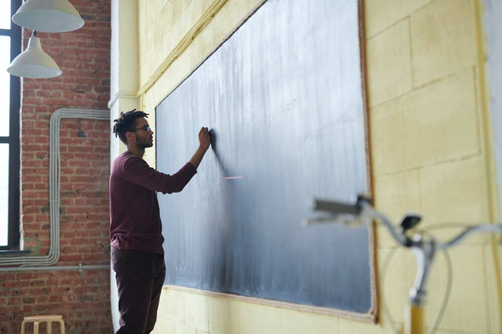 A teacher writting on a blackboard