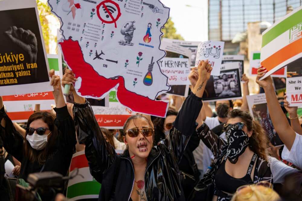 Protesters hold banners as they take part in a rally outside the Iranian consulate in Istanbul on September 29, 2022