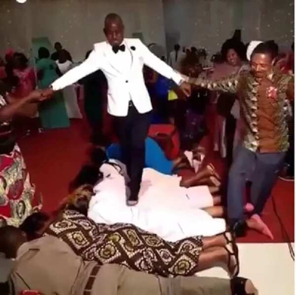 Viral photos of newlywed couple walking on guests at their wedding ceremony