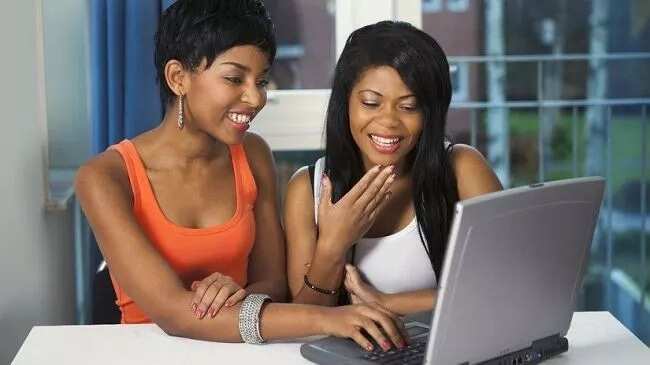 Two women smiling on laptop