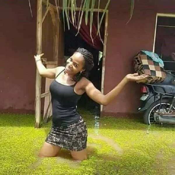 Young lady strikes a pose in front of her house as flood overtakes it in Benue state (photos)