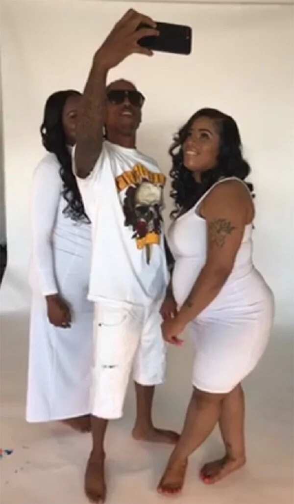 Man poses for pictures with his two pregnant girlfriends