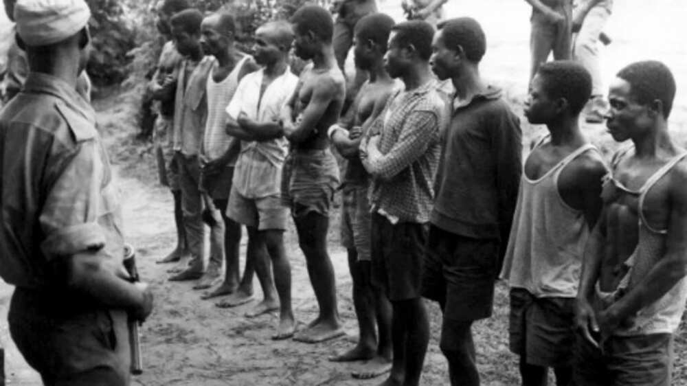 In the photo below, Nigerian federal army soldiers (R), prisoners of the Biafran army, wait to be questioned / AFP PHOTO